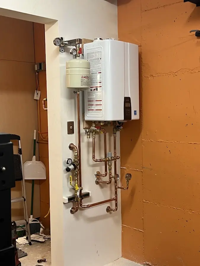 Plumbing technician inspecting water heater connections in Edwards